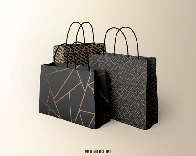 three black and gold shopping bags sitting side by side