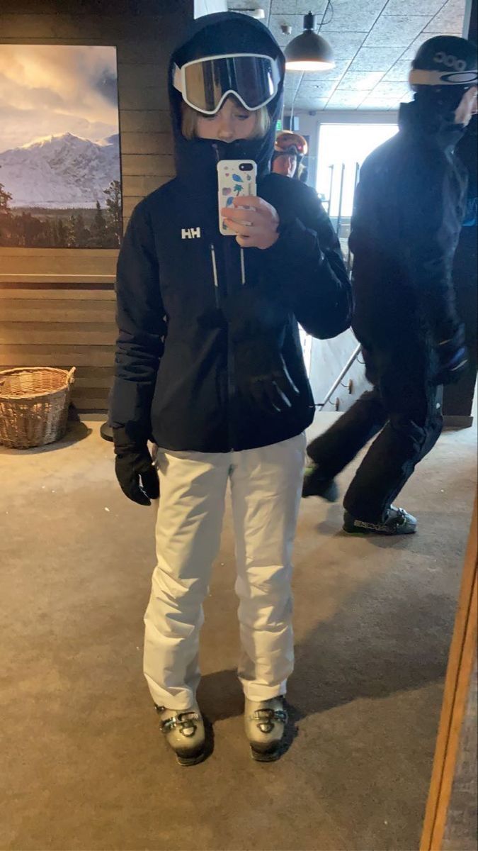 a person wearing skis and goggles taking a selfie in front of a mirror