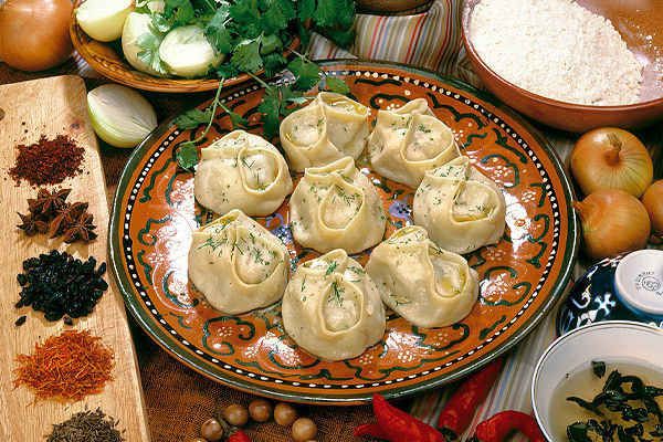 some dumplings are sitting on a plate next to other foods and vegetables, along with spices