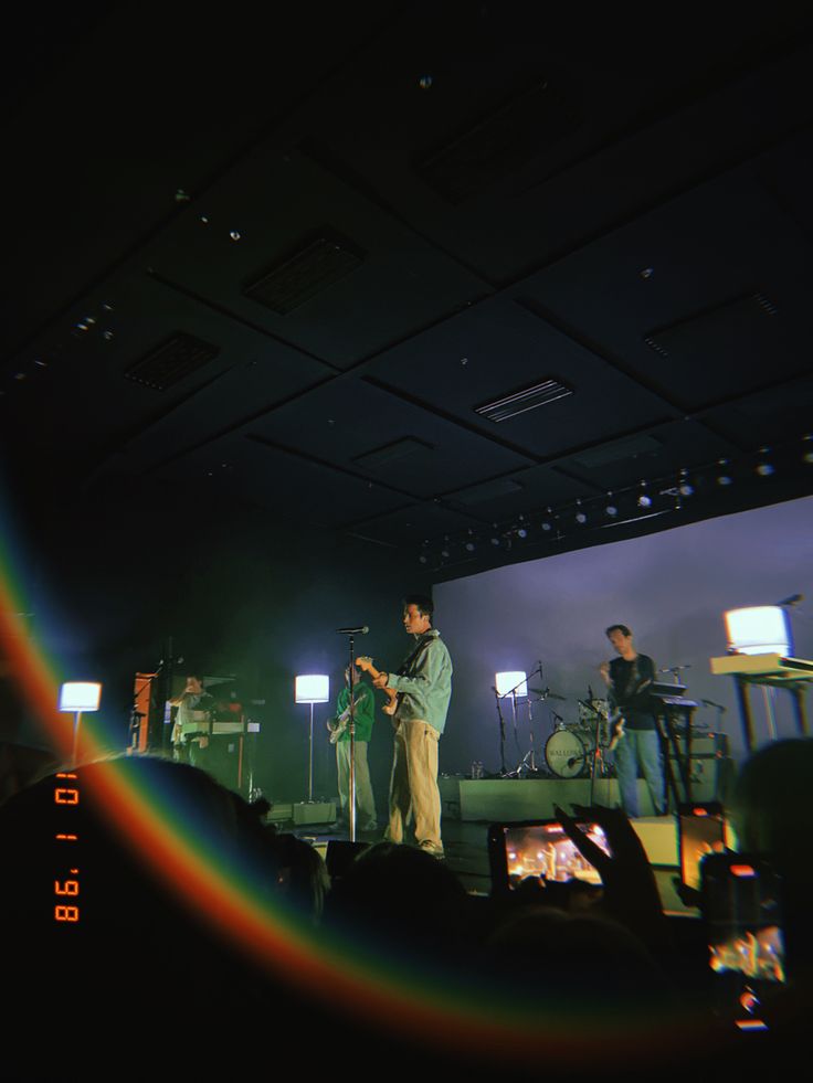 a man standing on top of a stage next to a rainbow