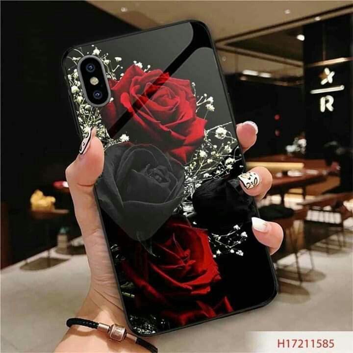 a woman holding up her phone case with a red rose and black bow on it