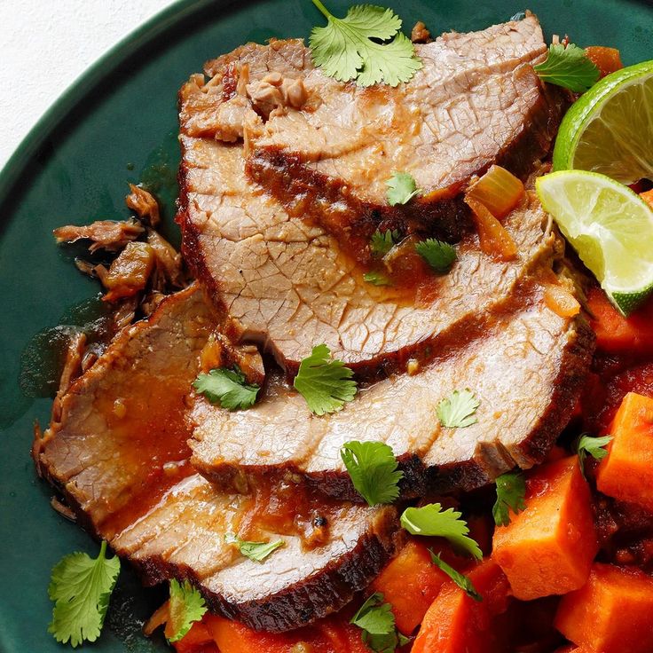 a green plate topped with meat and vegetables