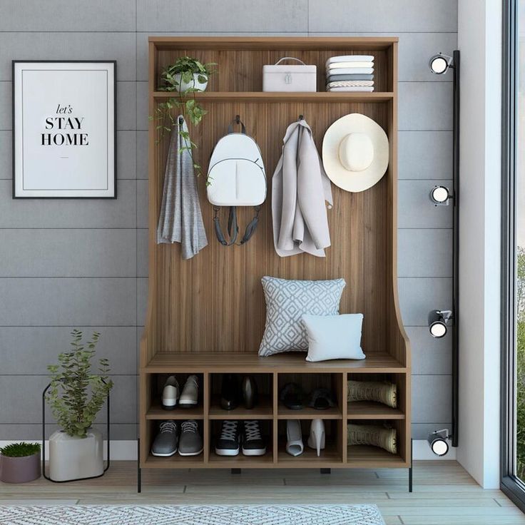 a coat rack with shoes, hats and other items on it next to a window