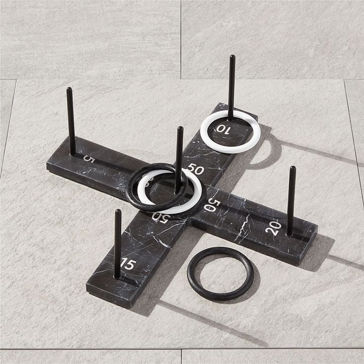 an object made out of black marble with white circles and numbers on the sides, sitting on a tile floor