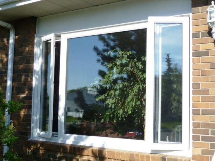 an image of a window that is open on the side of a brick building with trees in it