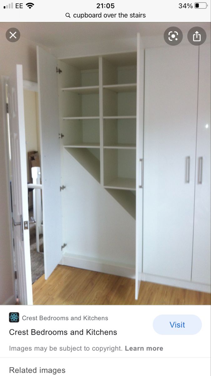 an empty room with white cupboards and wood flooring in front of the door