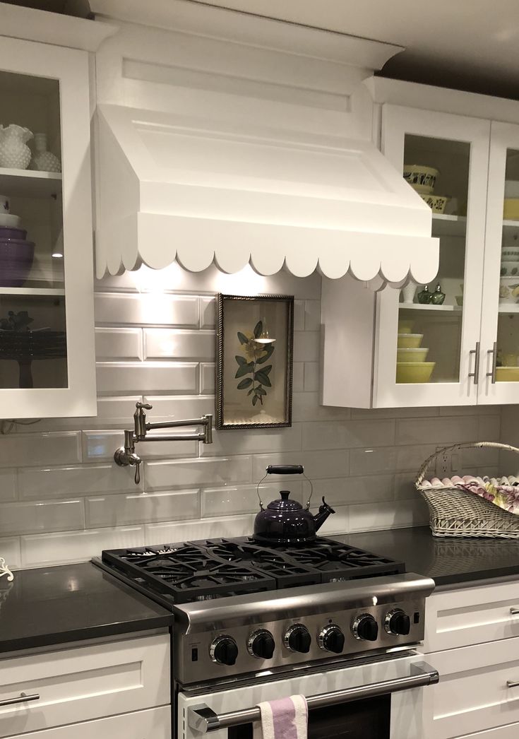 a stove top oven sitting inside of a kitchen under a white awning over it