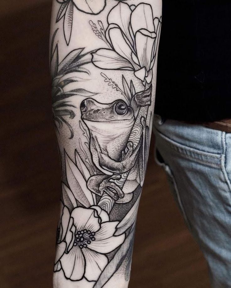 a person with a tattoo on their arm holding a flower and frog in the center