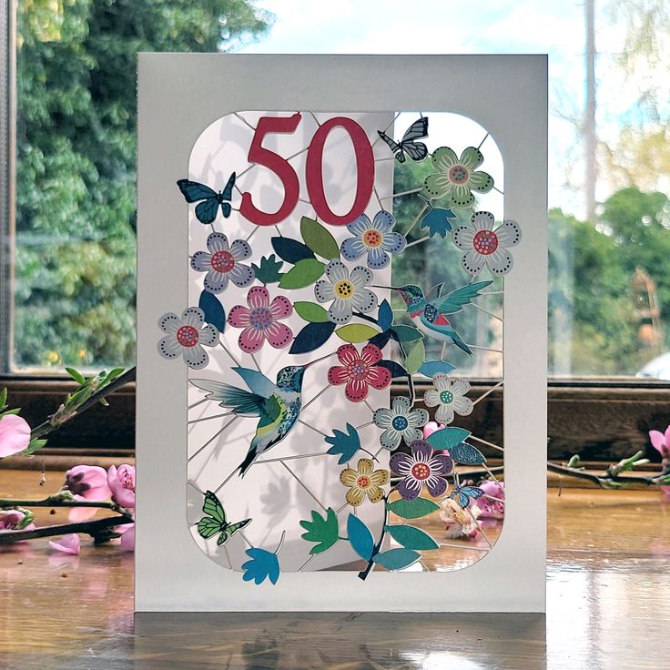 a greeting card with the number 30 on it and flowers in front of a window