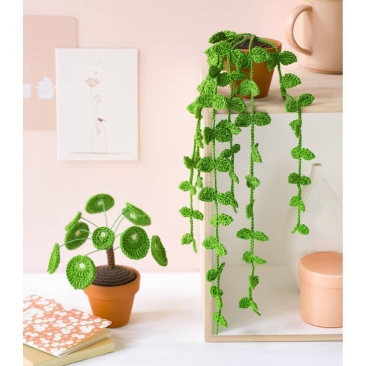 a potted plant sitting on top of a wooden shelf next to a cup and book