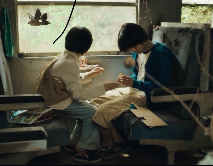 two people sitting on a bus looking at something