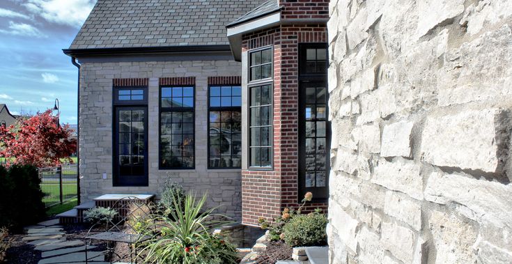 a brick house with large windows and landscaping