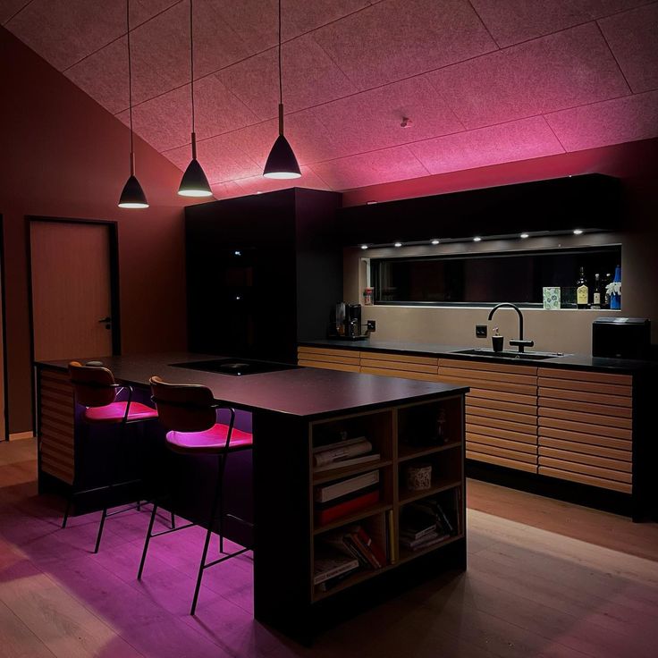 an empty kitchen with purple lighting in the ceiling and wooden flooring on the walls