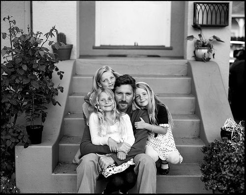 black and white photograph of family sitting on steps