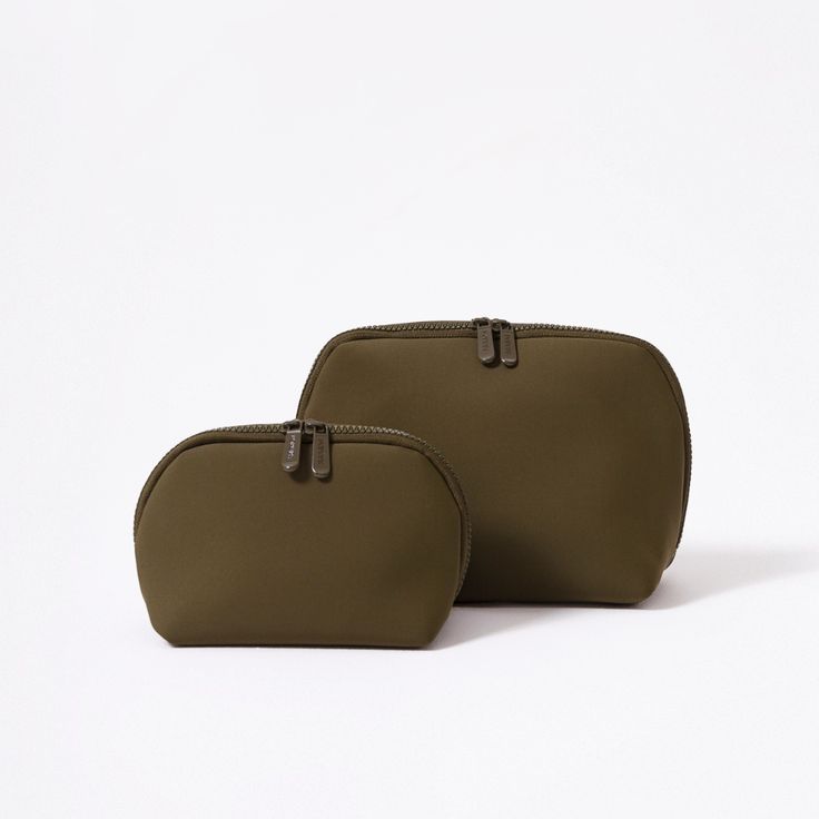 two bags sitting next to each other on a white surface and one has a zippered closure