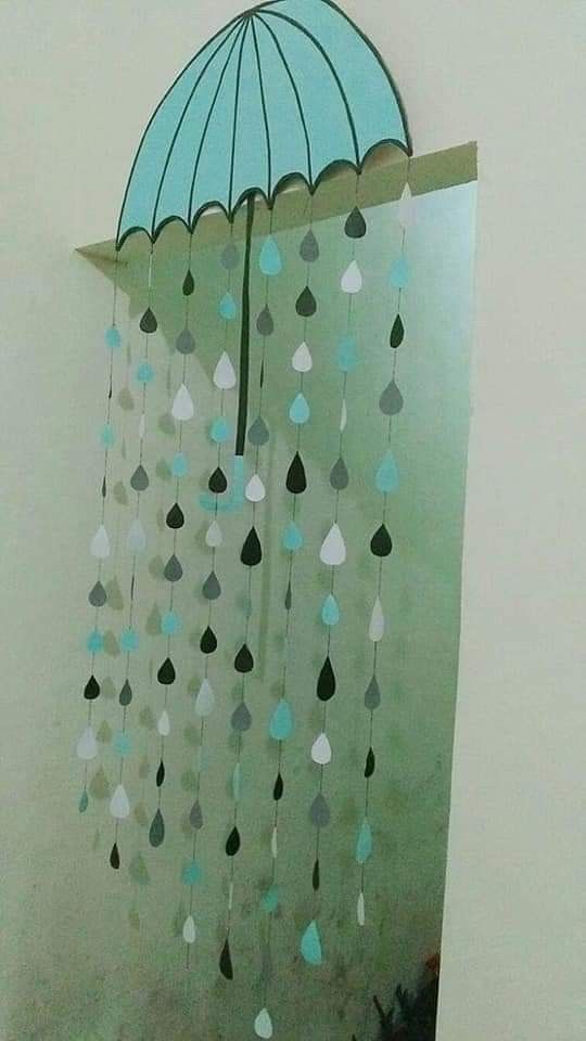 a blue umbrella hanging from the side of a wall next to a mirror with raindrops on it