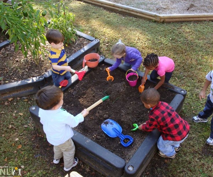 children are playing in the garden with shovels and sandboxes on the ground