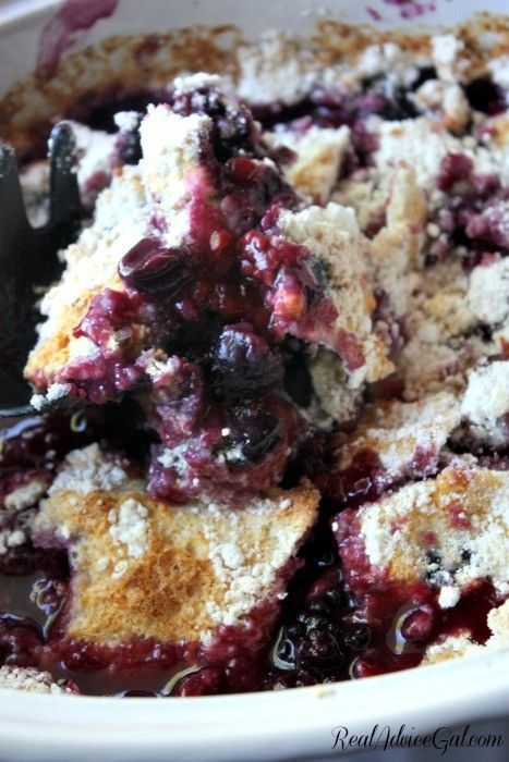 blueberry cobbler in a white bowl with a spoon