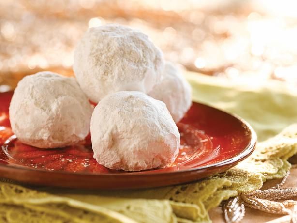 three snowball cookies sitting on top of a red plate