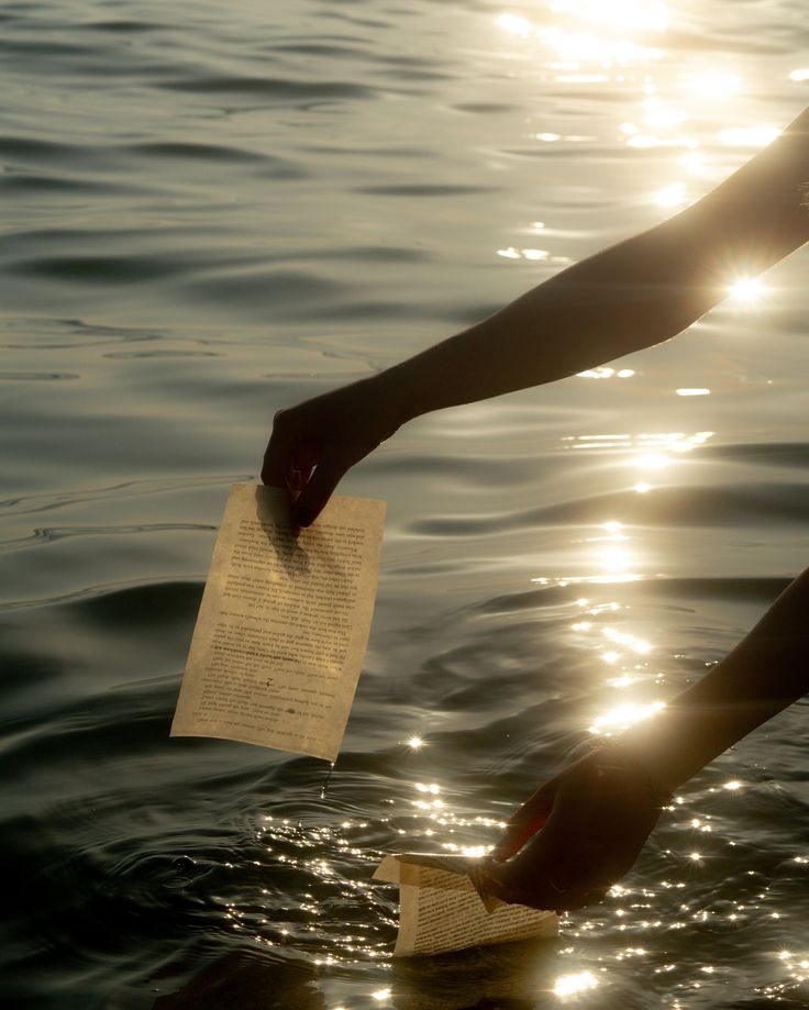 the person is holding a piece of paper in the water