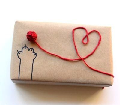 a wrapped gift with a red string attached to it and a heart on the top