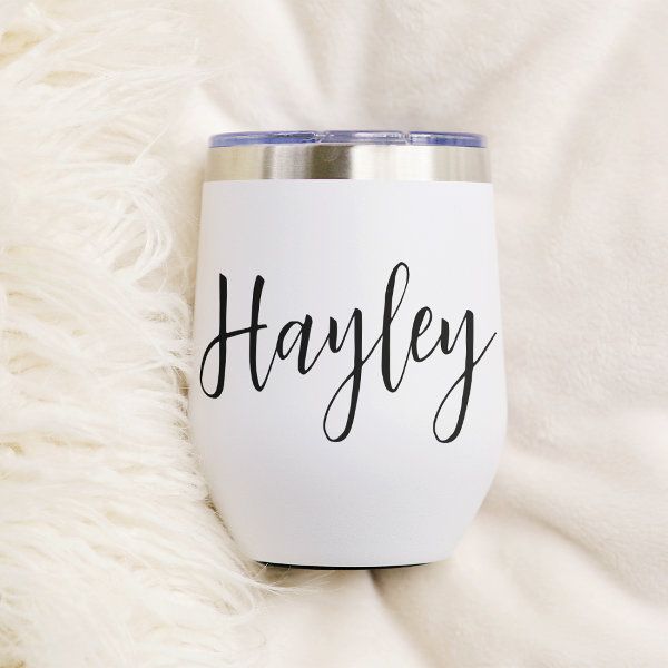 a white wine glass with the word hayley on it sitting on a fluffy blanket