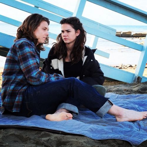 two women sitting on the ground talking to each other