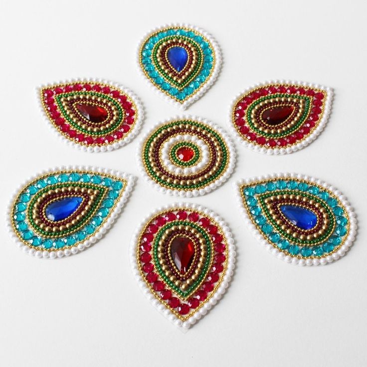 an image of beaded designs on white surface with red, green and blue beads