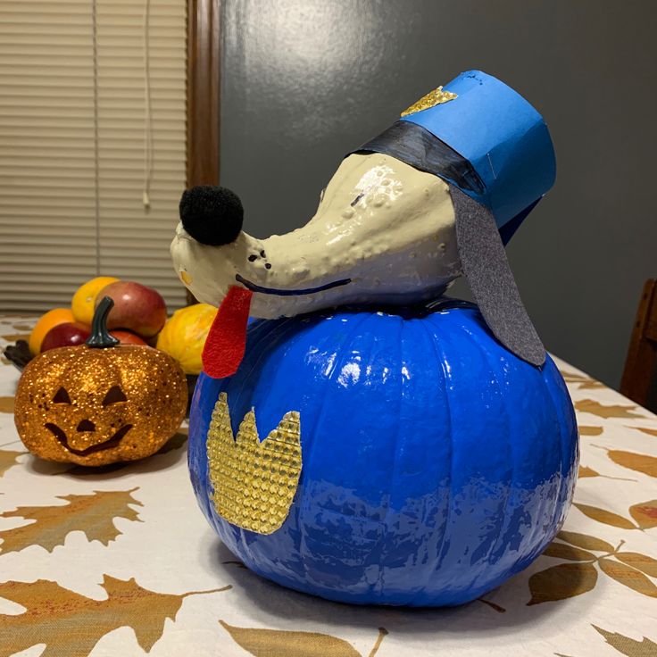 a dog statue sitting on top of a pumpkin