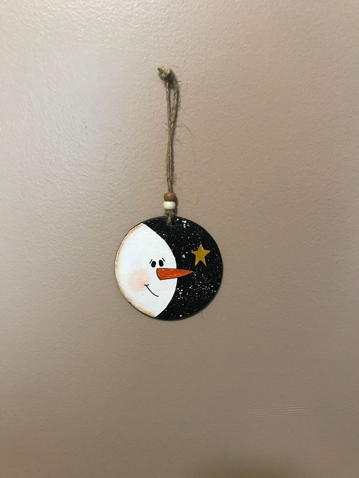 a snowman ornament hanging from the ceiling with a star on it's nose