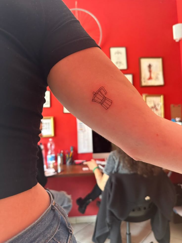 a woman's arm with a tattoo on it in front of a red wall