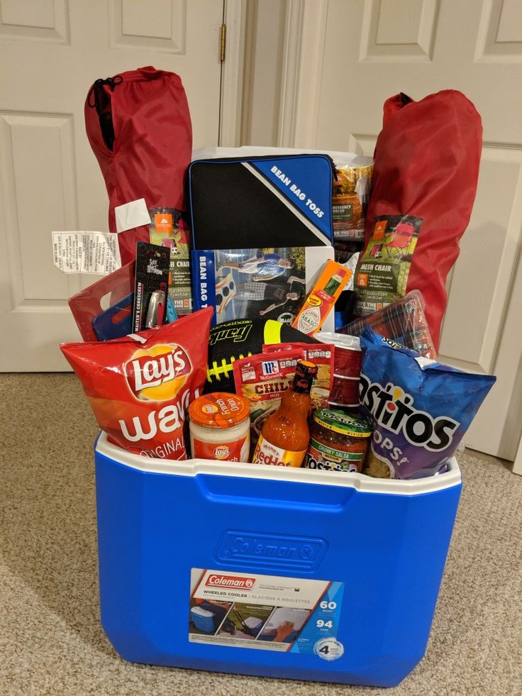 a blue cooler filled with lots of food on top of a carpeted floor next to a door