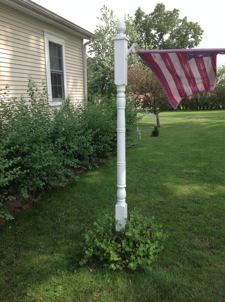 an american flag is hanging from a white pole