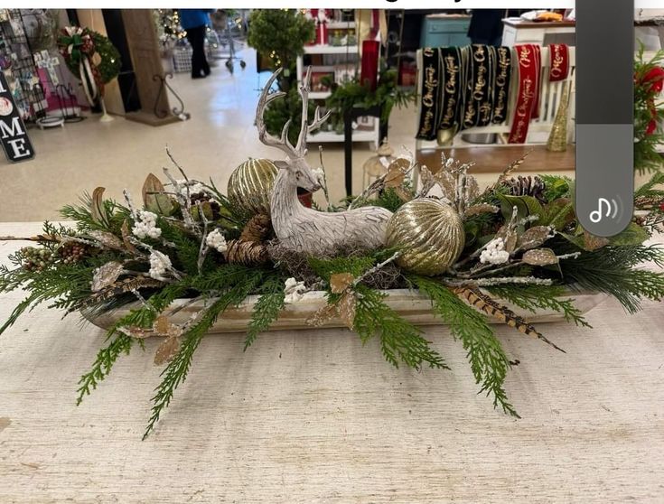 an image of a christmas centerpiece with deer and pine cones