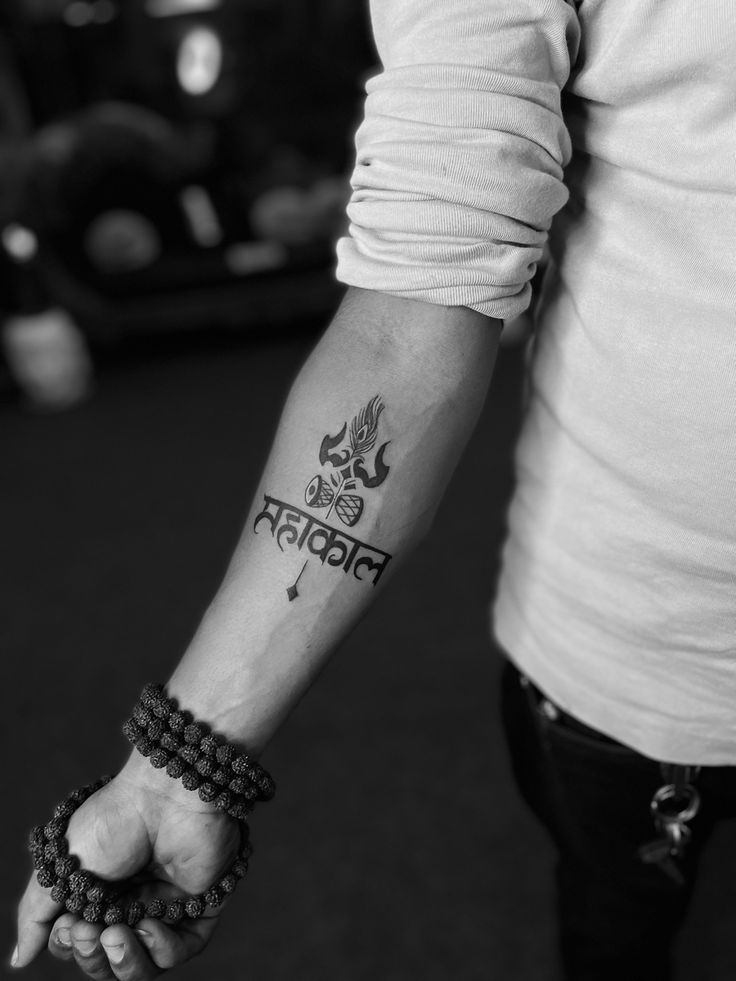 black and white photo of a person holding the hand of another person with a tattoo on their arm