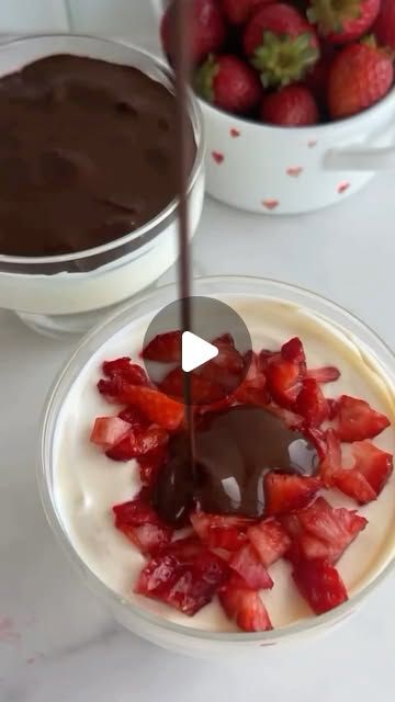 chocolate sauce being drizzled over strawberries in a bowl