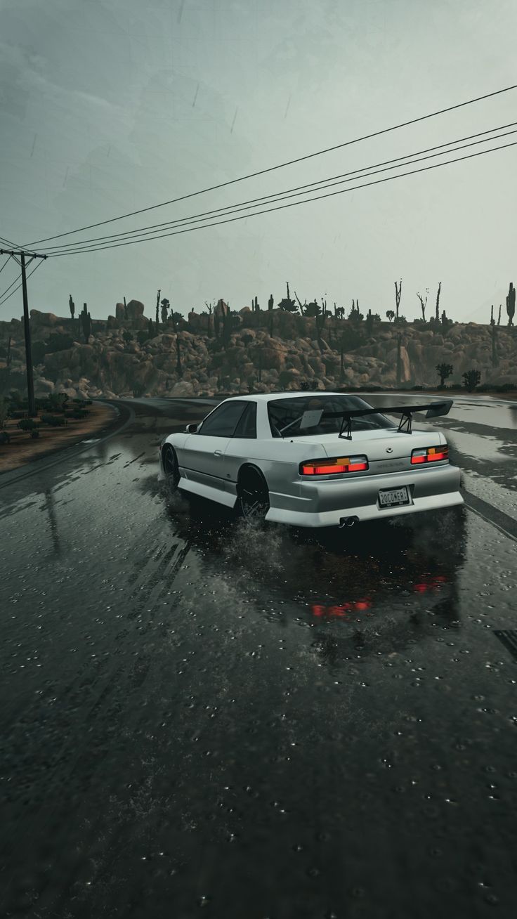 a white car driving down a wet road