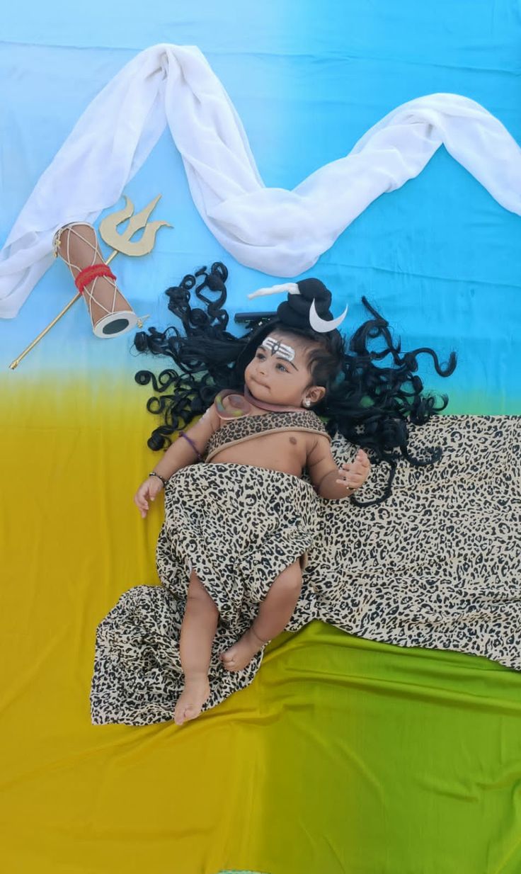 an image of a baby doll laying on top of a bed covered in animal print