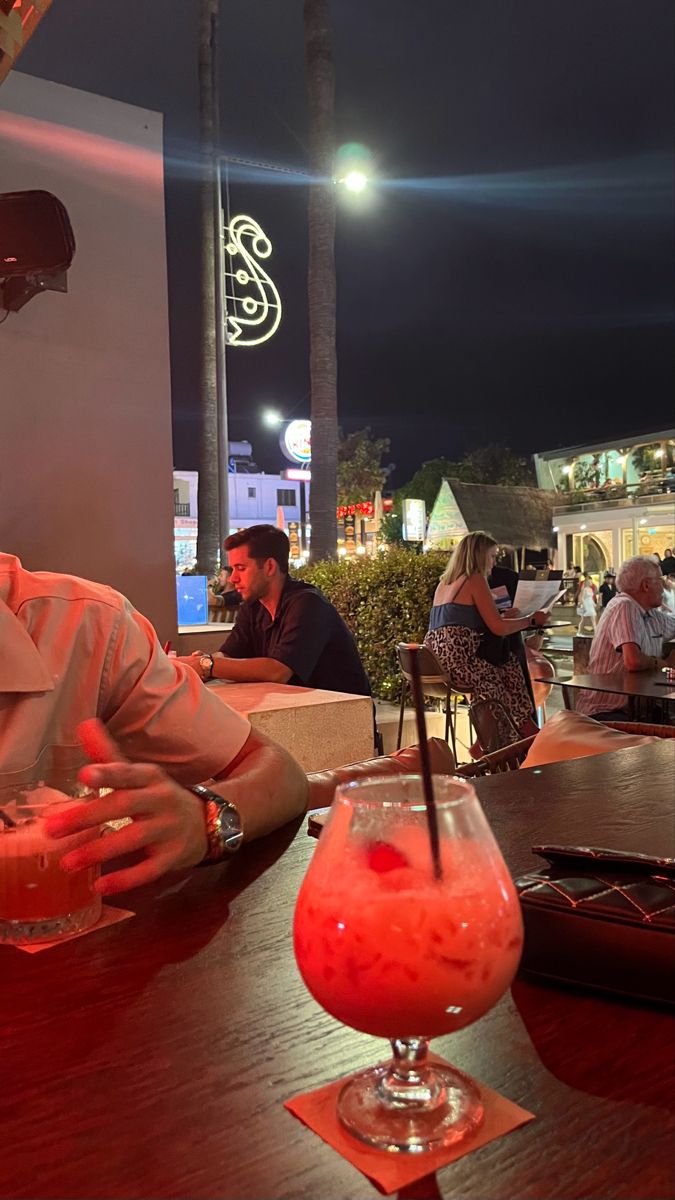 a man sitting at a table with a drink in front of him