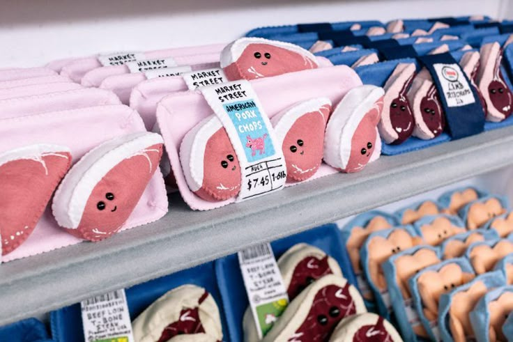 there are many different kinds of donuts on the shelves in this store, including one with pink and blue icing