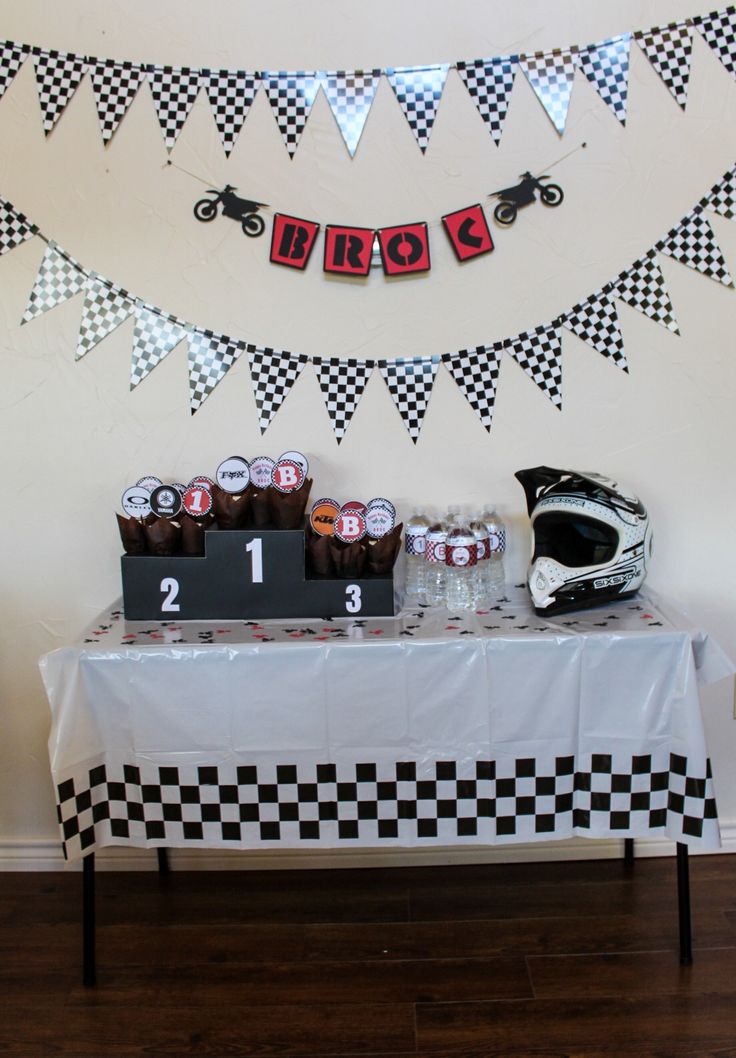 a motorcycle themed birthday party with checkered table cloths and race theme decorations on the wall