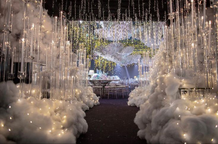 an entrance to a wedding decorated with white lights and chandelier hanging from the ceiling