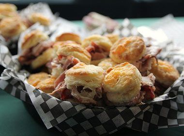 some food that is sitting in a basket on a green tablecloth with black and white checkered paper