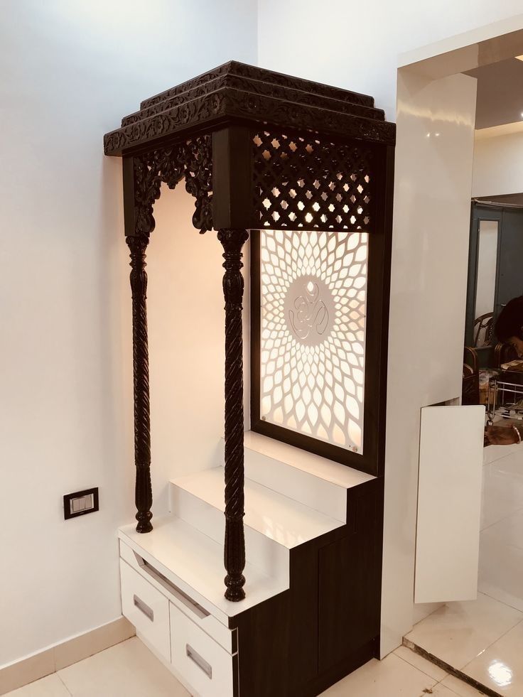 a white and black gazebo sitting in the middle of a room next to drawers