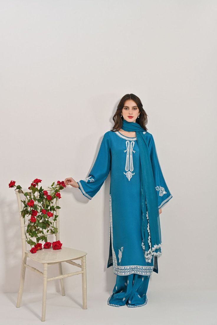 Canvassed on a jewel tone of teal blue in pure raw silk 60 gms with intricate threadwork in kashmiri stitch, styled with embellished flappers and pure embroidered chiffon dupatta with cutwork borders on four sides. Turns heads in “ Azal “ The length of the long kameez is 46 inches. Order Duration: 4 to 6 weeks Long Kameez, Embroidered Chiffon, Chiffon Dupatta, Cut Work, Jewel Tones, Raw Silk, Teal Blue, Borders, Chiffon