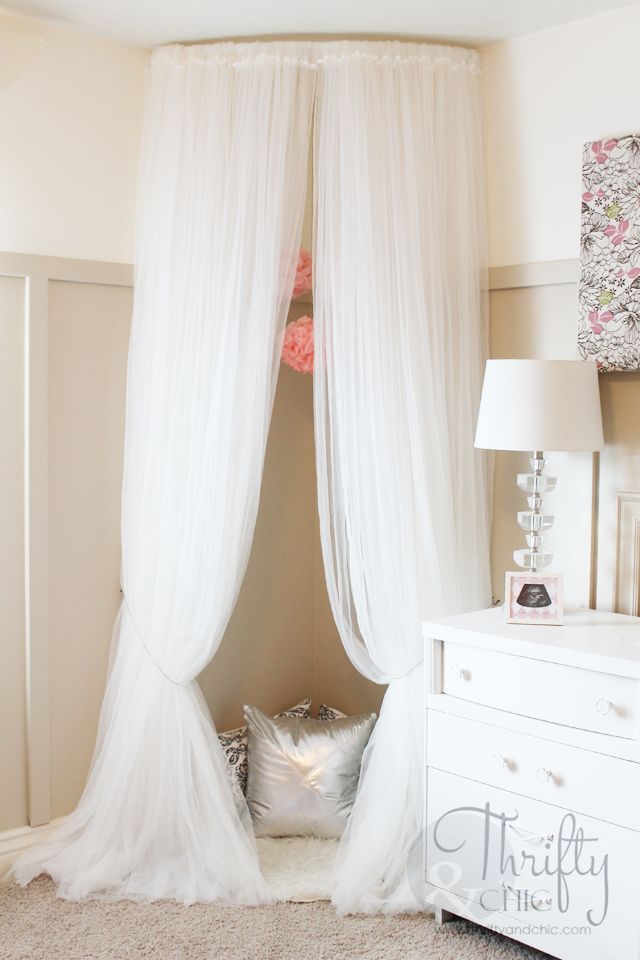 a white canopy bed in a bedroom next to a dresser