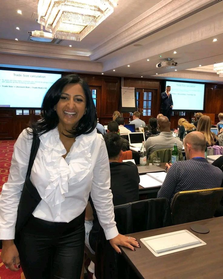 a woman standing in front of a room full of people