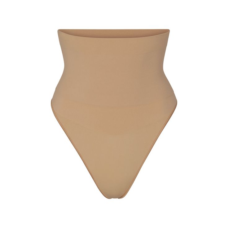 Get ultimate compression with our highest support level in this high-rise shapewear thong that sculpts, smooths, and tones your core and tummy. Wear this silky staple under everything to enhance your natural shape. Features removable adjustable straps. | SKIMS High-Waisted Thong | Medium Neutral | Core Control Solid Sculpting Shapewear With Seamless Construction, Sleek Second-skin Bottoms With Smoothing Detail, Sleek Second-skin Smoothing Bottoms, Seamless Sculpting High-cut Leg Shapewear, Solid Full Coverage Sculpting Shapewear, Contoured Seamless Solid Shapewear, Smoothing And Sculpting Shapewear, Beige Smoothing Sculpting Shapewear, Beige Sculpting Smoothing Shapewear