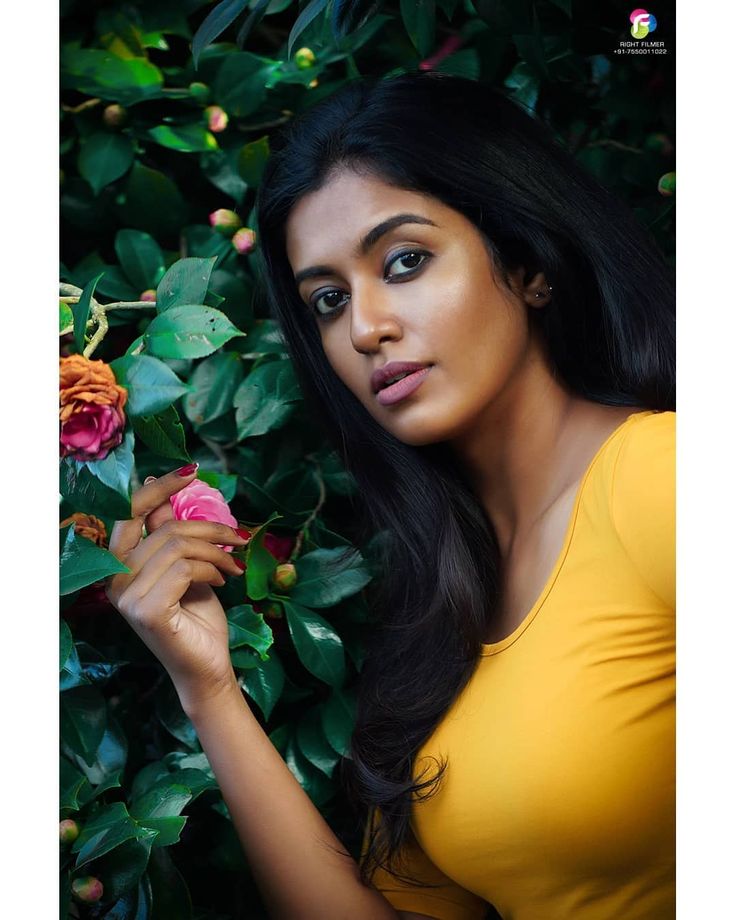 a beautiful young woman holding onto a pink rose