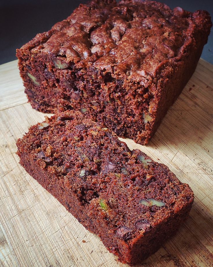 a loaf of chocolate cake sitting on top of a wooden cutting board